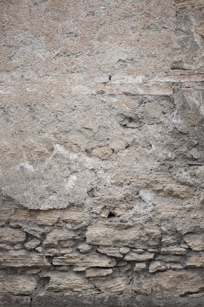 Fragment of old grungy texture with chipped paint and cracks or grey concrete wall and cement surface