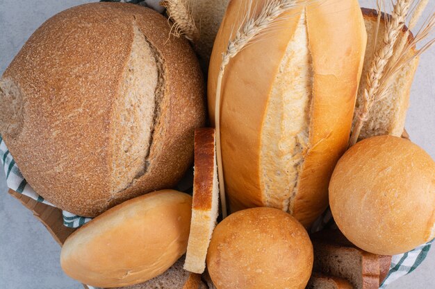 Fragrant bread in basket on marble surface