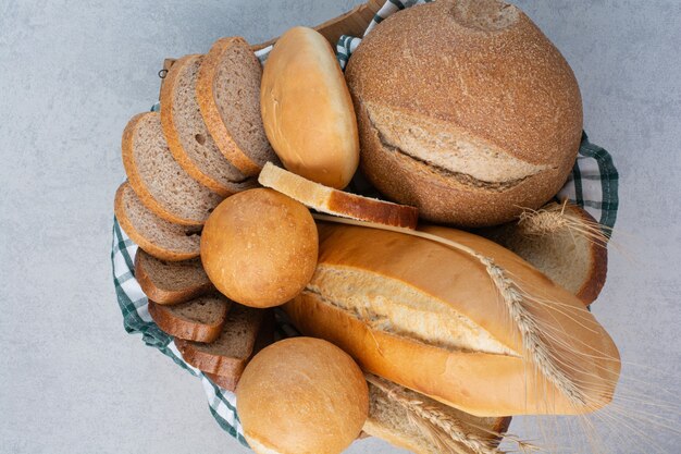 Fragrant bread in basket on marble surface