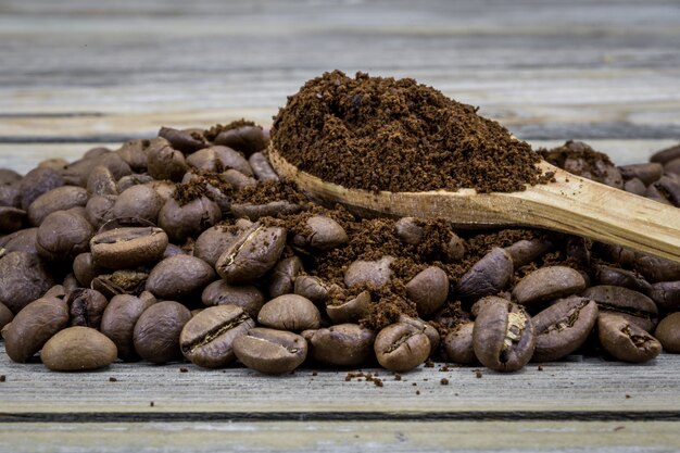 fragrant coffee beans in a beautiful wooden spoon on wood