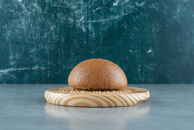 Fragrant rye bun on wooden plate with barley.