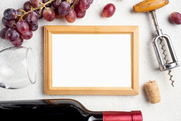 Foto gratuita cornice accanto a bottiglia di vino e uva