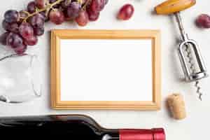 Free photo frame beside wine bottle and grapes
