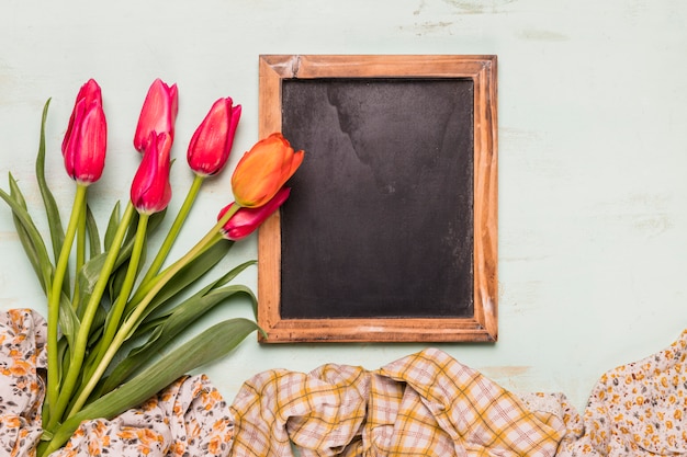 Free photo frame blackboard with bouquet of tulips