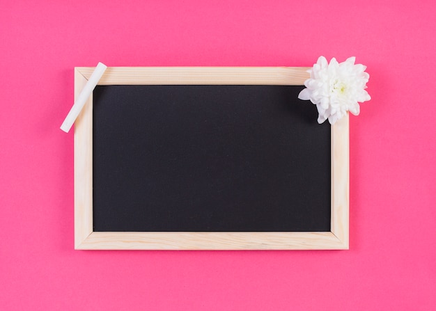 Frame blackboard with chalk and flower