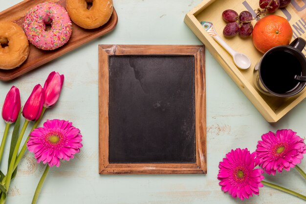 Frame blackboard with flowers and breakfast set