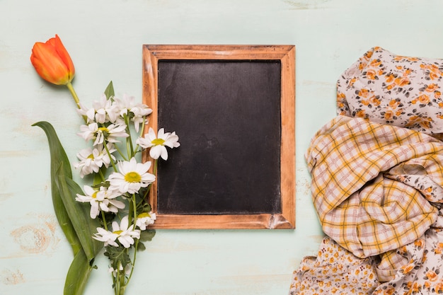 Frame blackboard with flowers and shawls