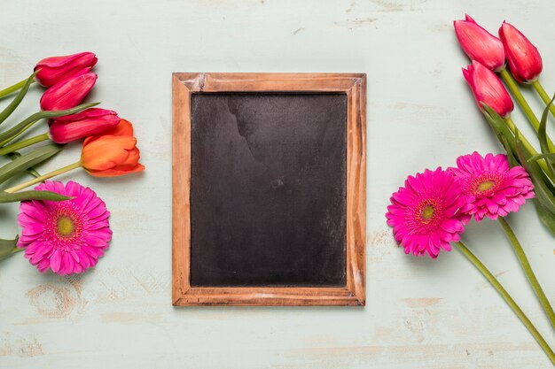 Frame chalkboard with bouquets of flowers 