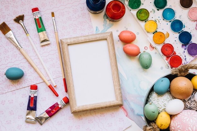 Frame and eggs with colors and brushes