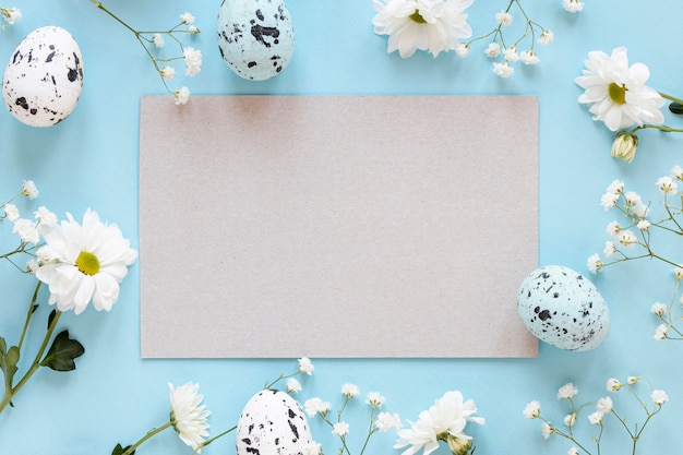 Frame of flowers with paper sheet and eggs