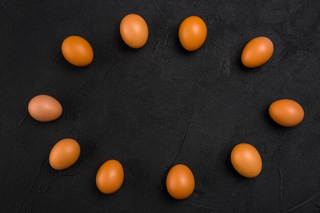 Frame from brown chicken eggs on black table