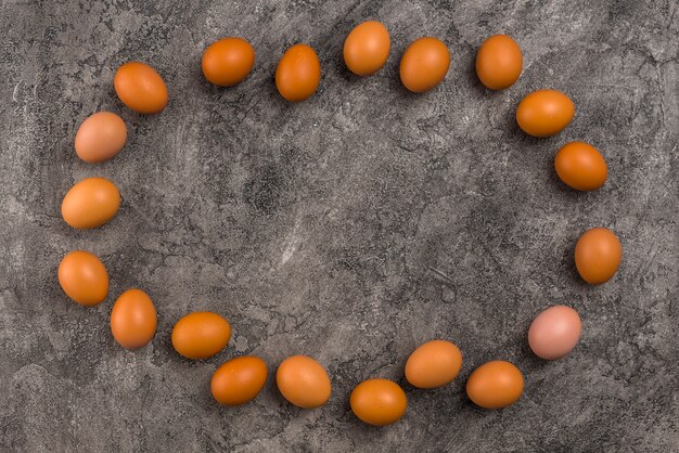 Frame from brown chicken eggs on grey table