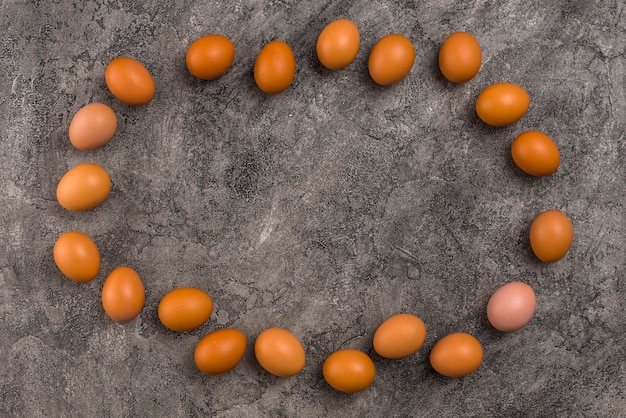 Frame from brown chicken eggs on grey table