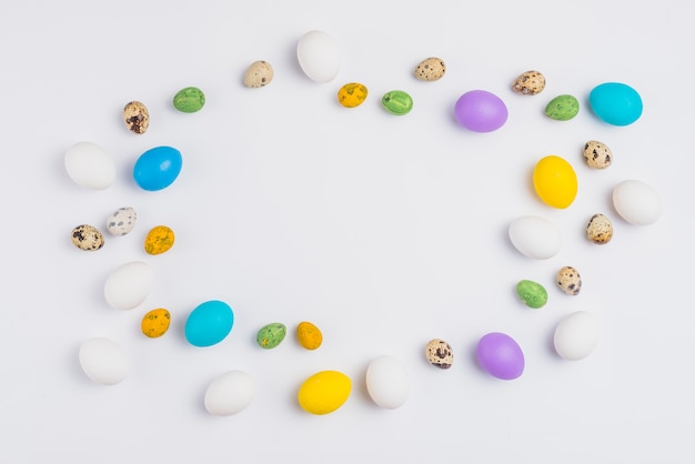 Frame from colorful Easter eggs on white table