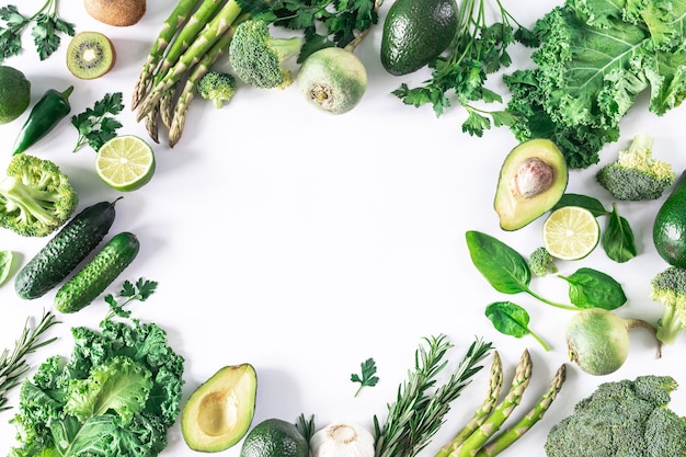 Cornice di verdure fresche verdi su uno sfondo bianco il concetto di cibo crudo menù vegano