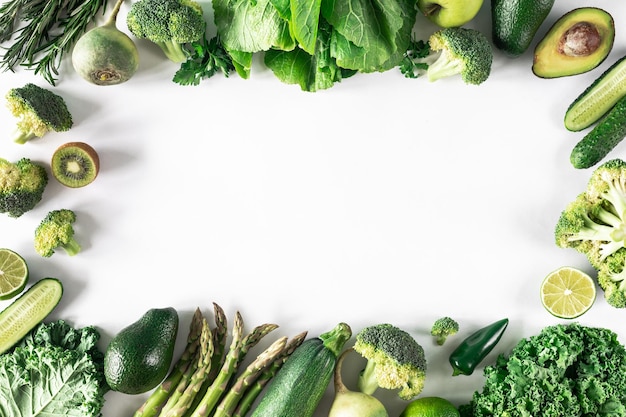 Рамка из зеленых свежих овощей на белом фоне Концепция сырой пищи