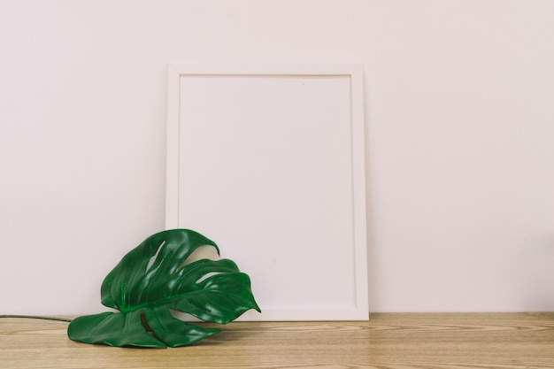 Frame leaning against wall with leaf