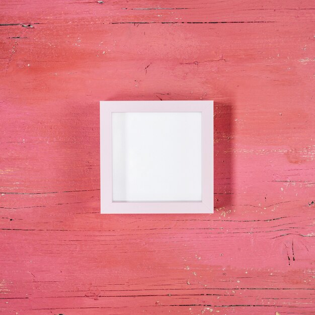 Frame on light pink wooden background