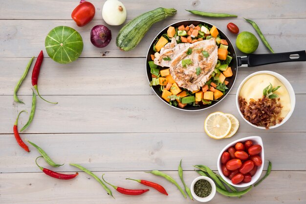 Frame made of healthy vegetables and fried pan with meat