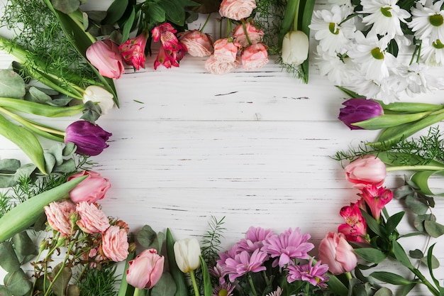 Foto gratuita telaio realizzato con diversi tipi di bellissimi fiori sulla superficie in legno