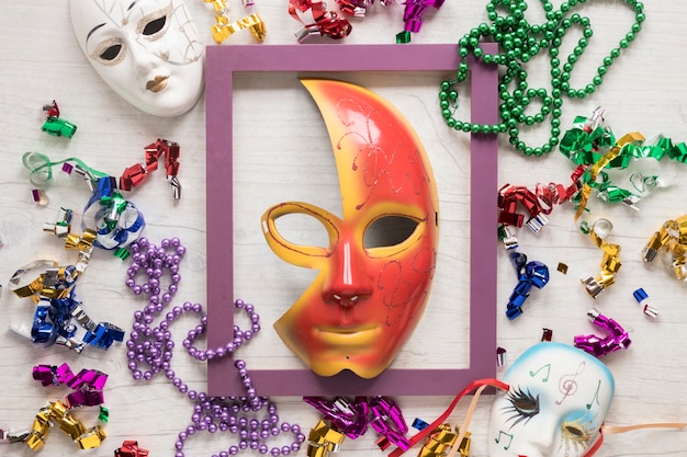 Frame and mask amidst confetti and beads