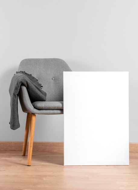 Free photo frame mock up beside chair