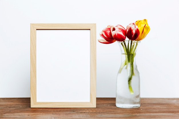 Frame near vase with flowers