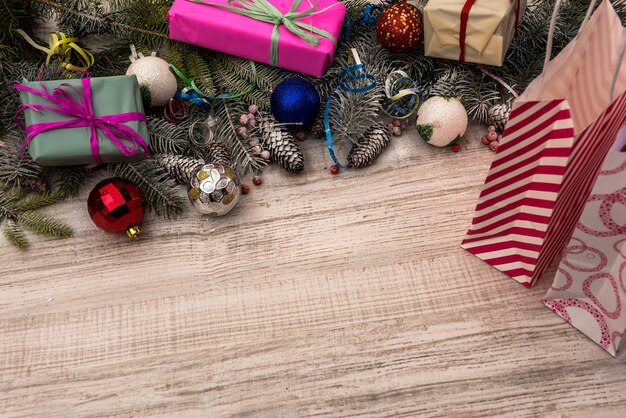 木製​の​テーブル​の​上​の​ギフト​ボックス​と​モミ​の​枝​の​フレーム​。​クリスマス​の​お祝い