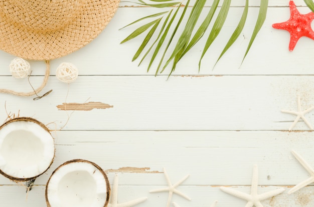 Frame of straw hat, sea stars and palm leaf