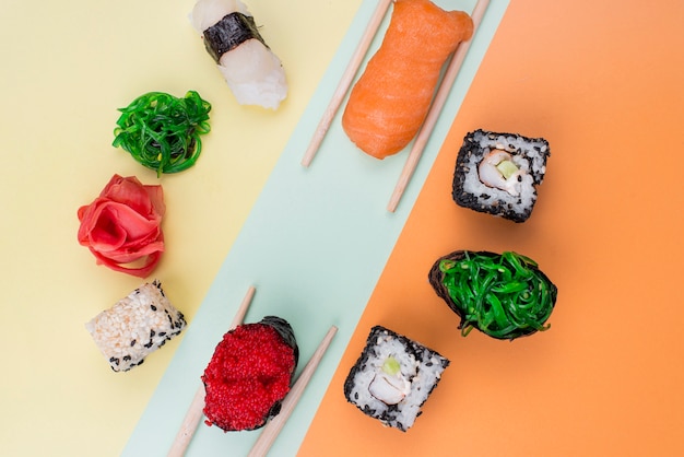 Foto gratuita cornice di sushi con le bacchette sul tavolo