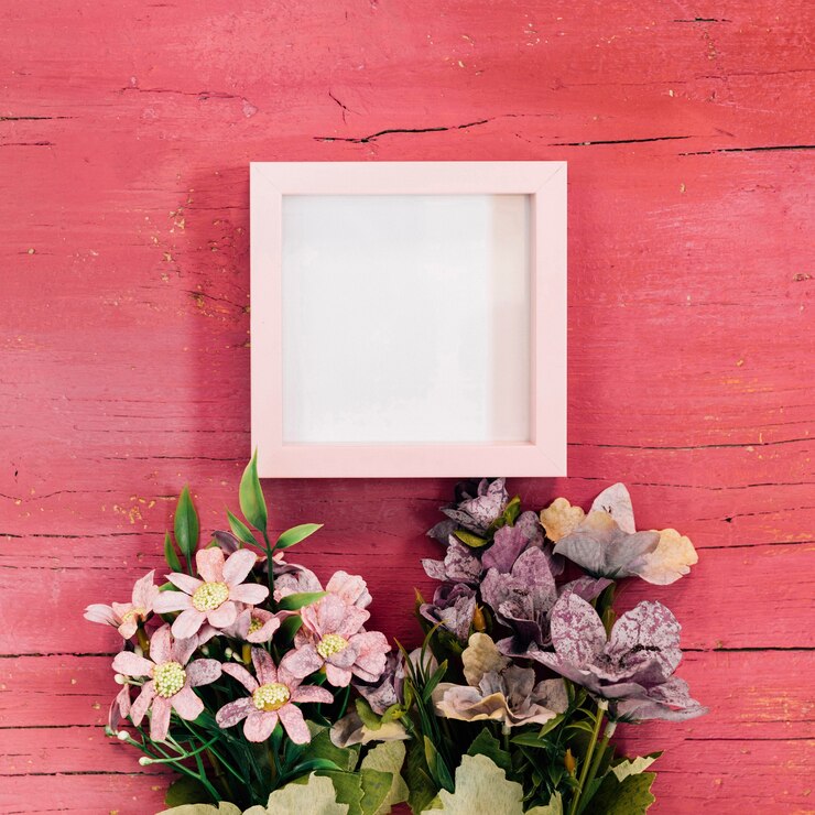 Free Photo frame with flower bouquets on pink wooden background