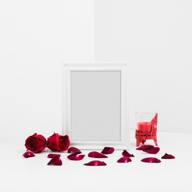 Frame with red roses on table 