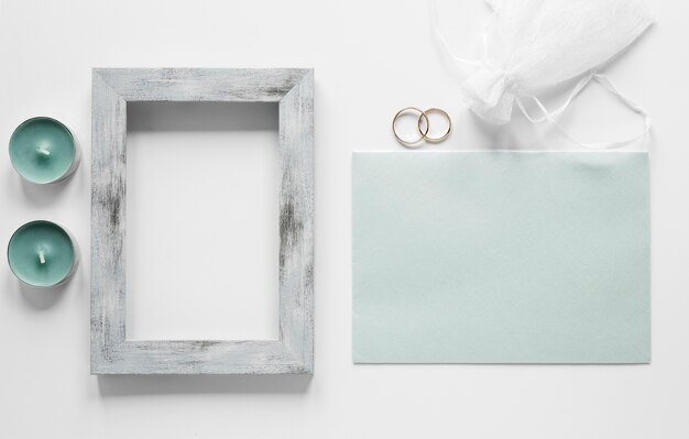 Frame with wedding card on table