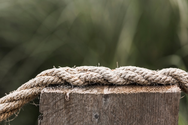 Free photo frayed ship rope on wooden post