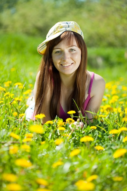 Free photo freckle woman relaxing in dandelion