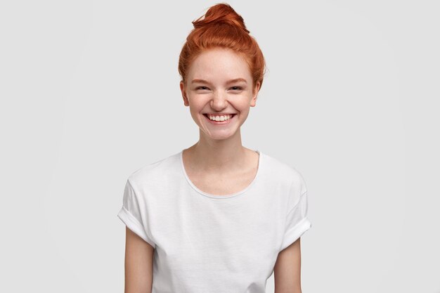 freckled young lady or teenager smiles joyfully at camera