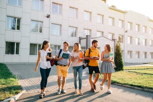 Tempo libero di studenti, ritmo di vita del campus universitario. cinque studenti amichevoli stanno camminando
