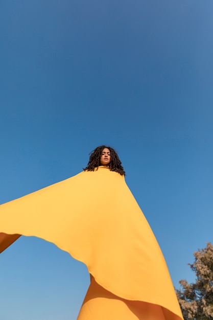 Free photo freedom concept with woman holding cloth in nature