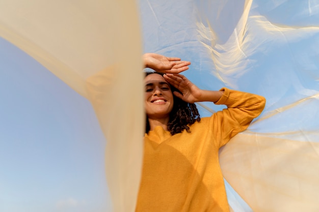 Foto gratuita concetto di libertà con il panno della tenuta della donna in natura