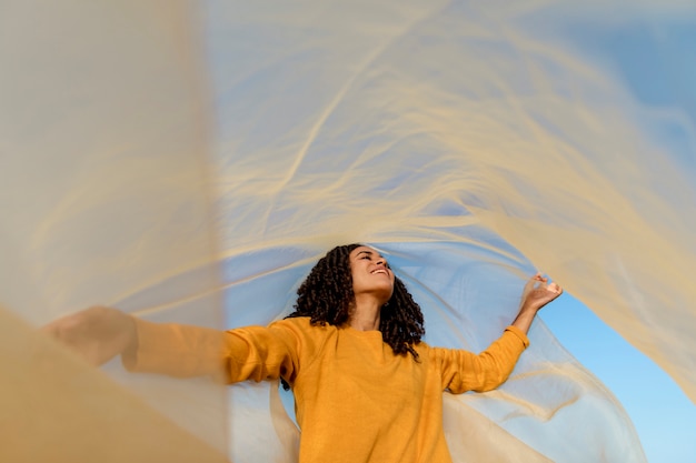 Freedom concept with woman holding cloth in nature