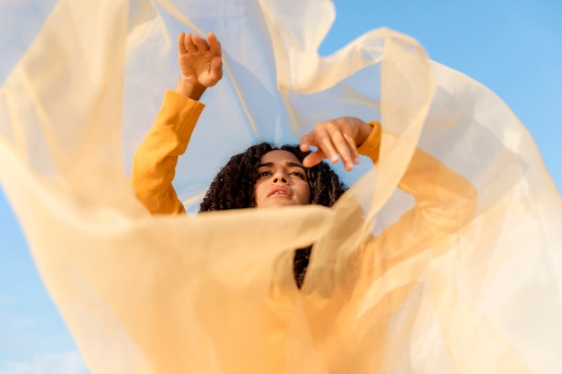 Freedom concept with woman holding cloth in nature