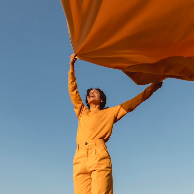 Free photo freedom concept with woman holding cloth in nature