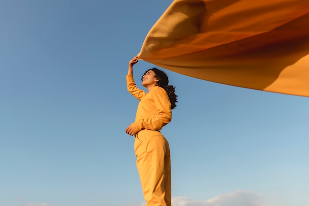 Freedom concept with woman holding cloth in nature