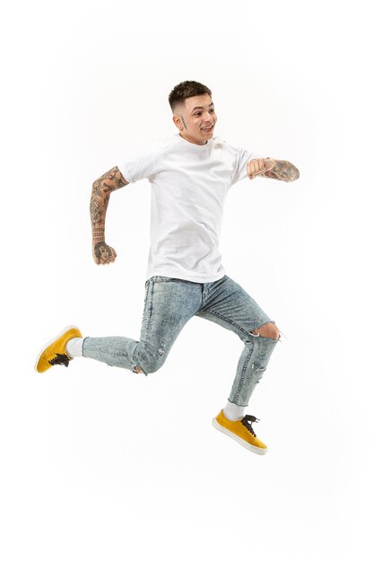 Freedom in moving. handsome young man jumping against white background