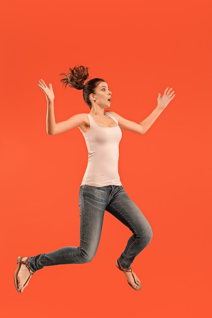 Freedom in moving. Mid-air shot of pretty happy young woman jumping