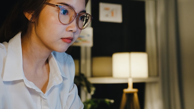 Free photo freelance asia lady using laptop hard work in living room at house.