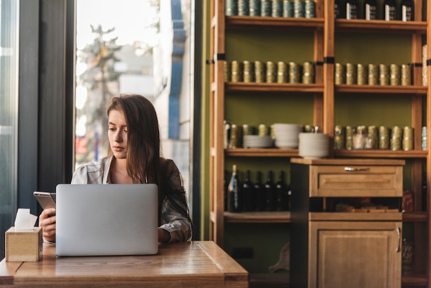 Freelance woman working with laptop in coffee shop