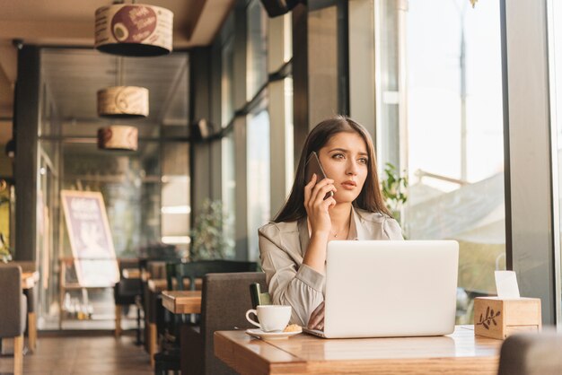 Freelance woman working with laptop in coffee shop