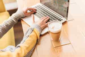 Free photo freelance woman working with laptop in coffee shop