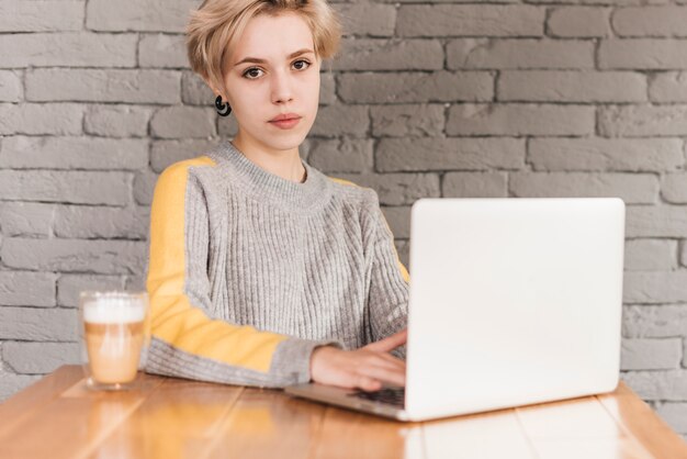 Freelance woman working with laptop in coffee shop